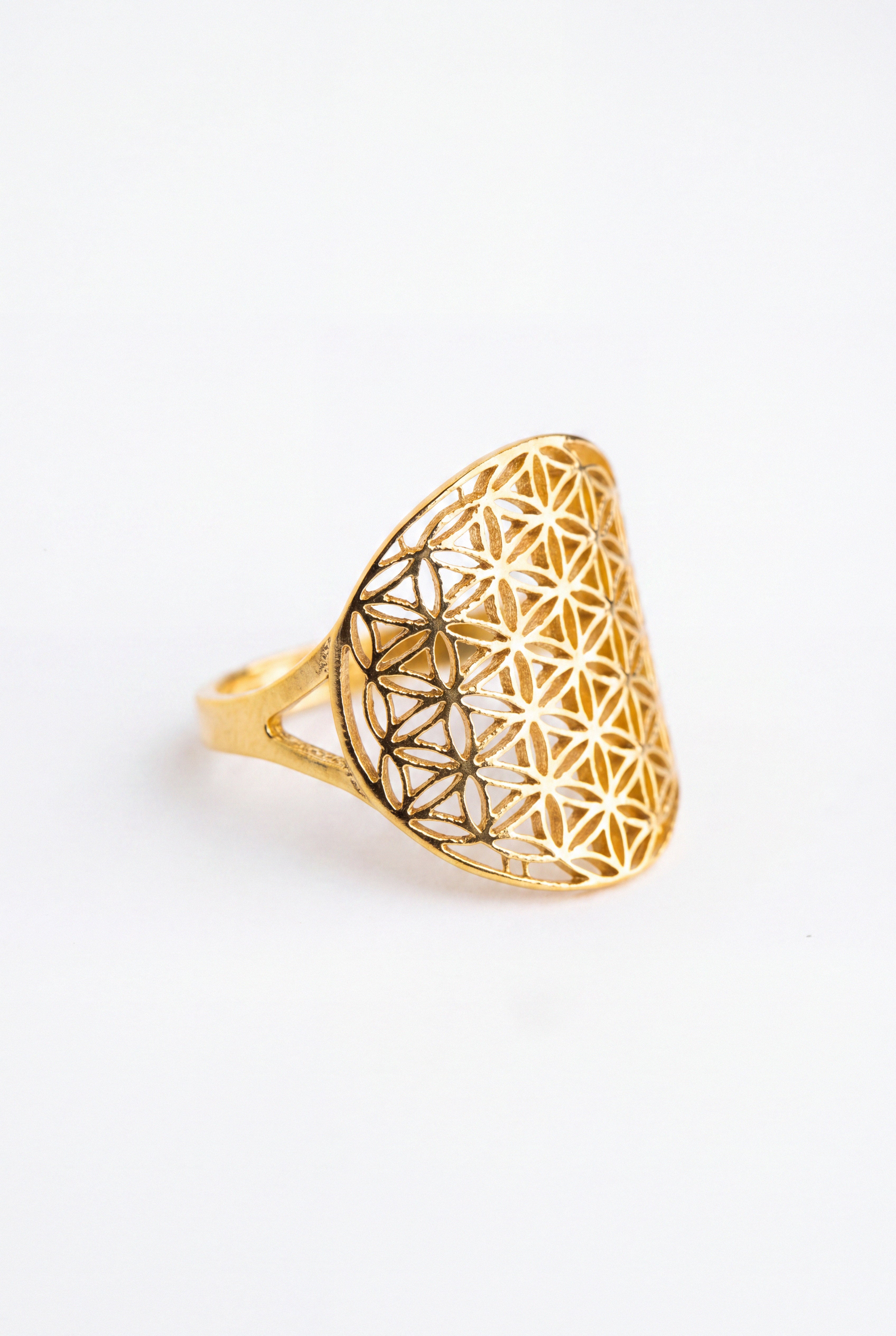 A gold ring featuring a large, openwork geometric flower design on a white background.